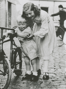 876088 Portret van Kees en zijn zus Annie Gijssen bij een fiets in de Achterstraat in Wijk C te Utrecht.